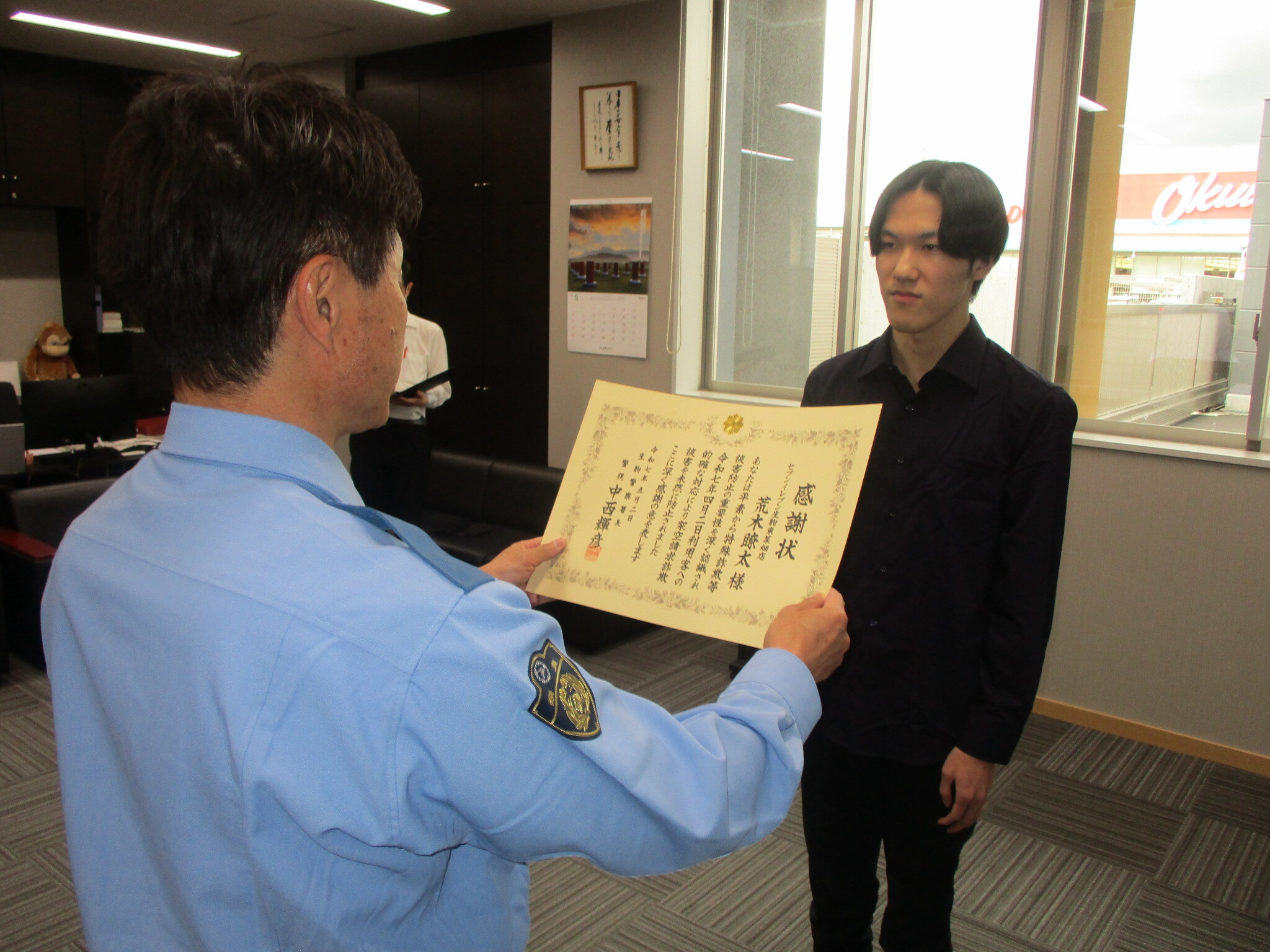 コンビニエンスストア店員が生駒警察署長から感謝状を受け取る様子　2