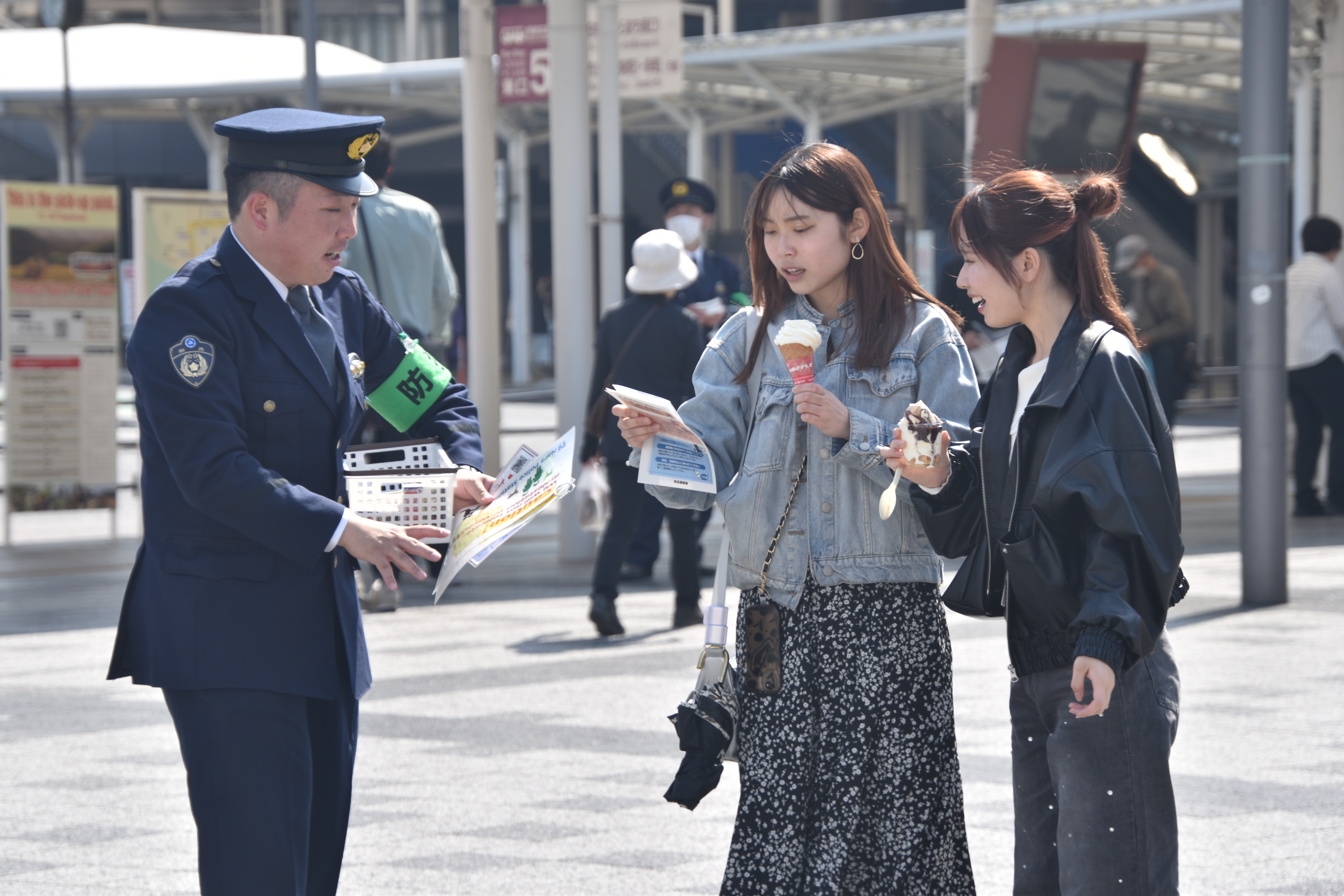 警察官が歩行者へ迷惑行為に向けた注意喚起の呼びかけをしている様子