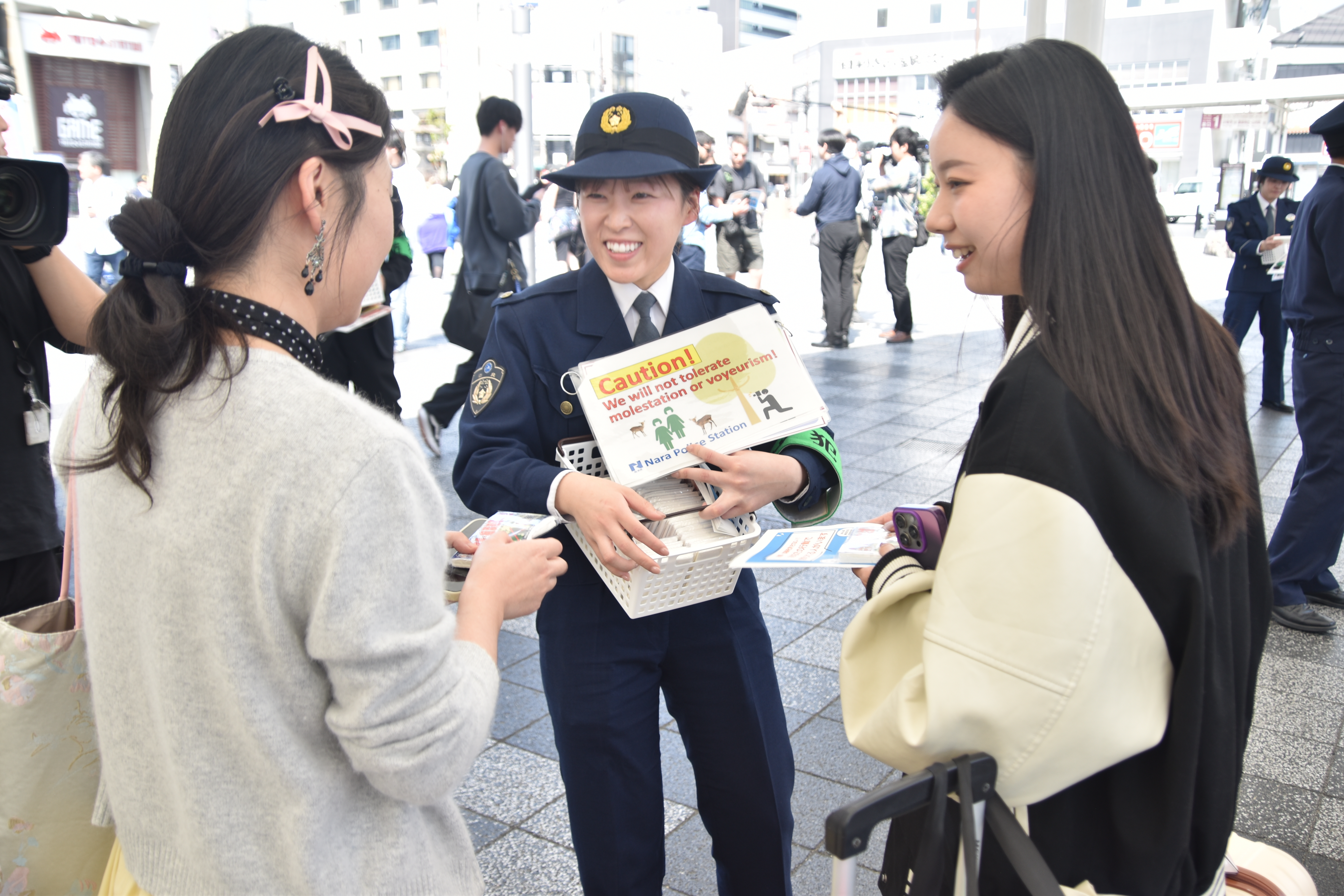 警察官が歩行者へ迷惑行為撲滅の説明をしている様子