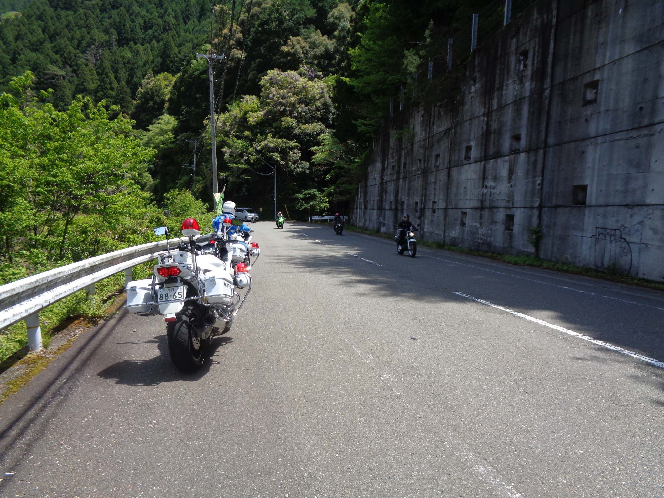 白バイ隊が山間部を走行するバイクへ注意喚起をしている様子2