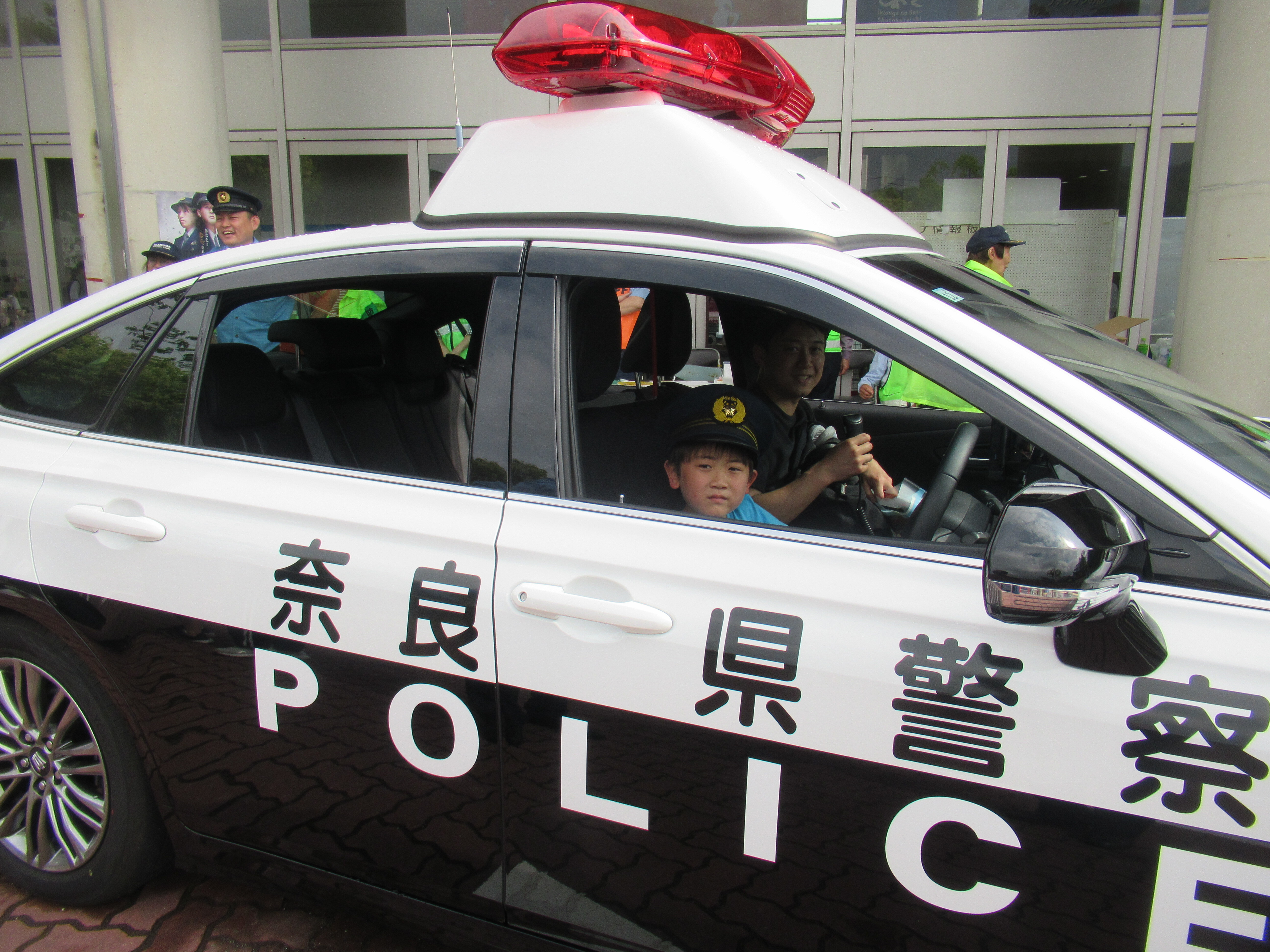 パトカーに乗る来場者