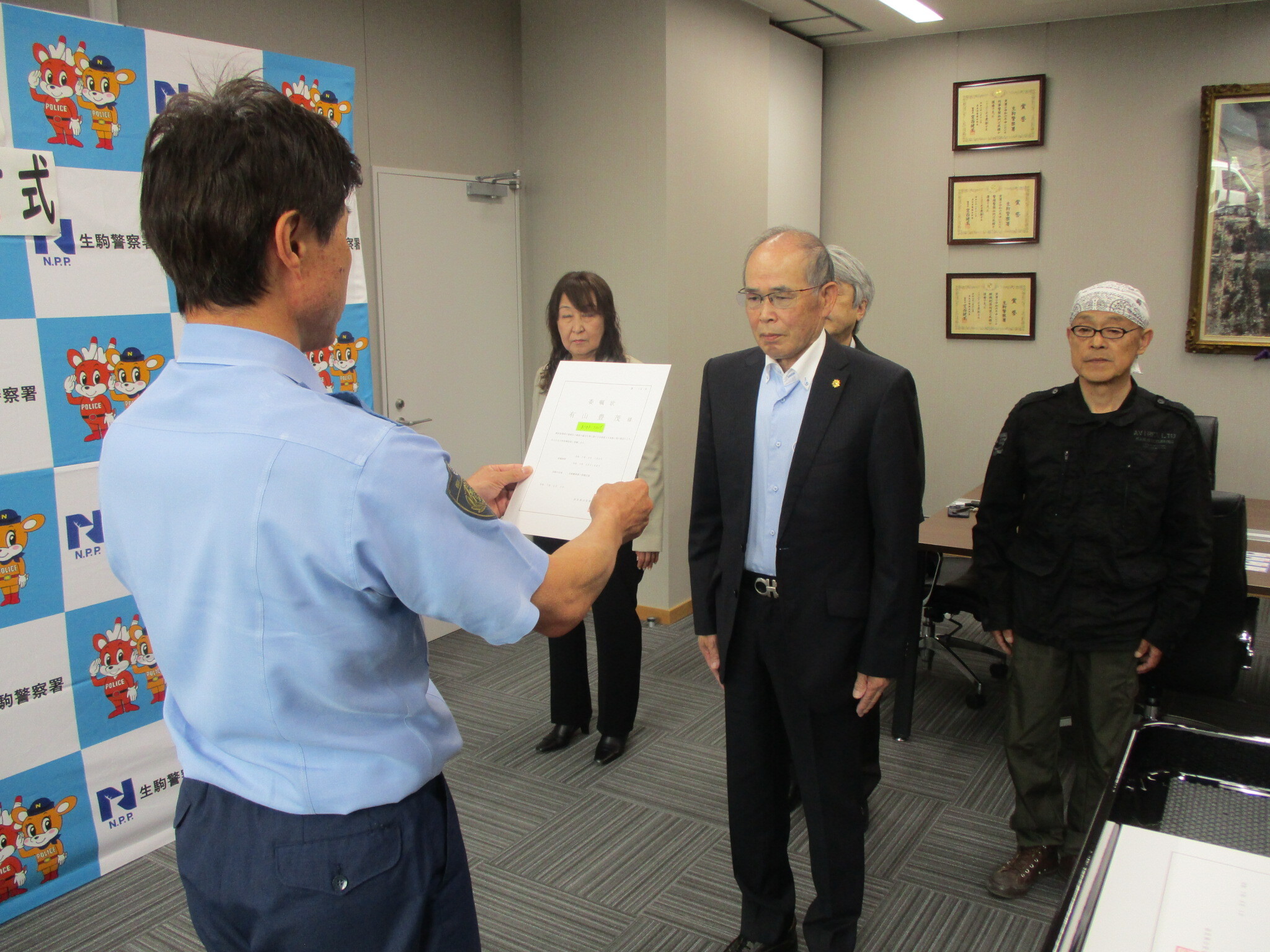 生駒警察署長から少年指導委員の方に委任状を渡している様子