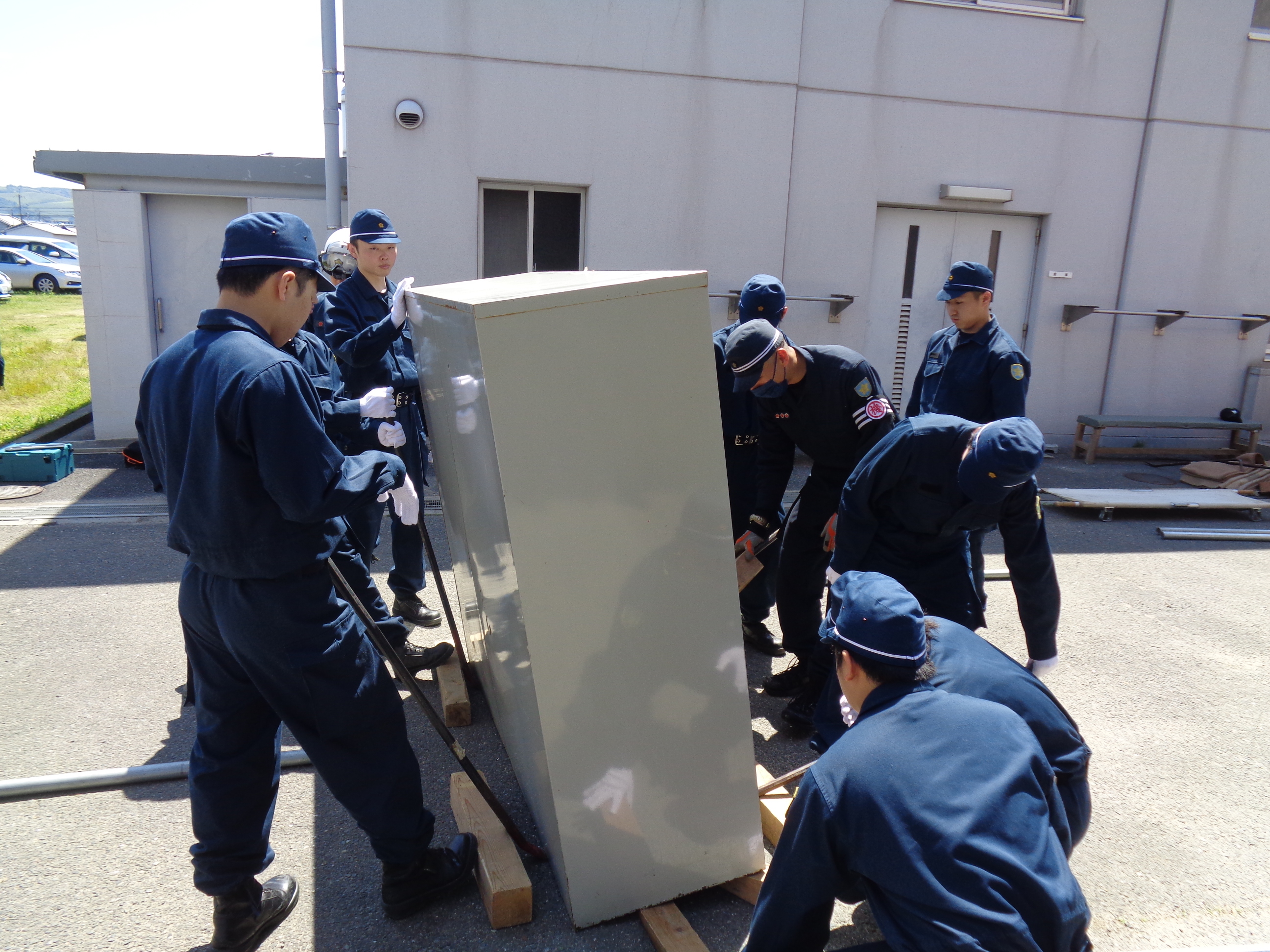 警察学校生、機動隊員みんなでロッカーを運んでいる様子