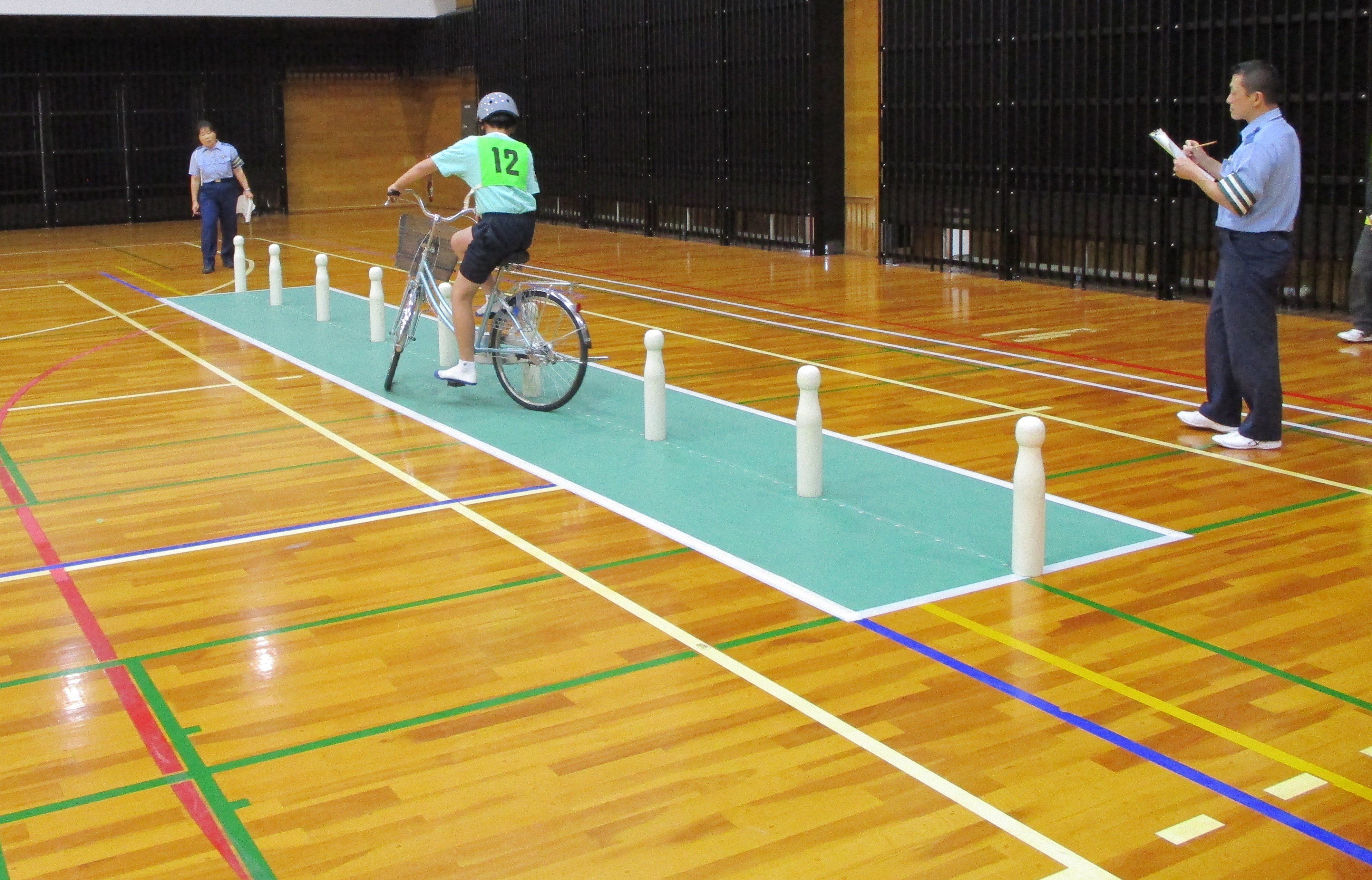 自転車でポールをよけながらジグザグに走行している様子