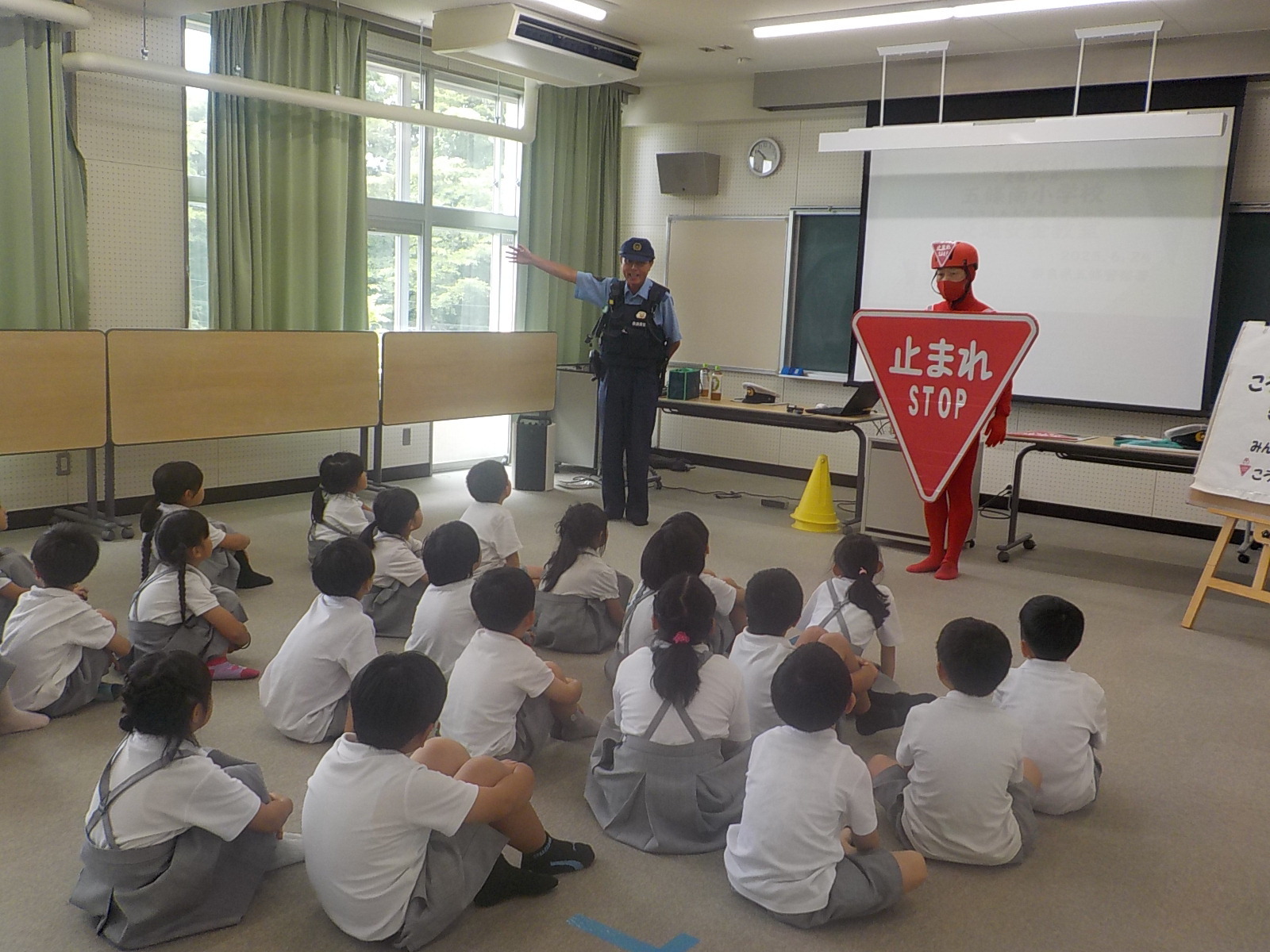 ストップマンと警察官が児童達に指導している様子