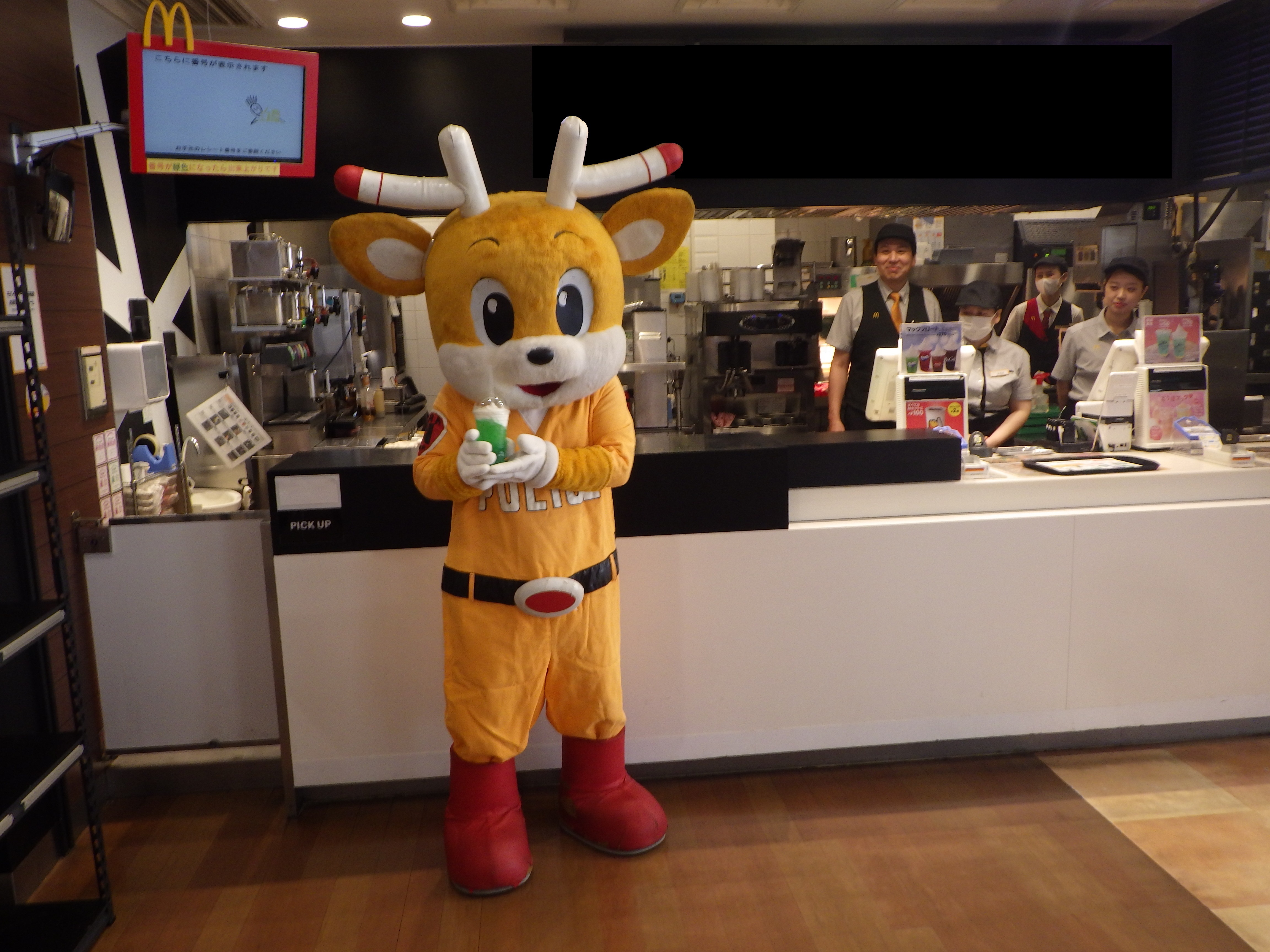 ナポくんがマックフロートを持って立っている様子