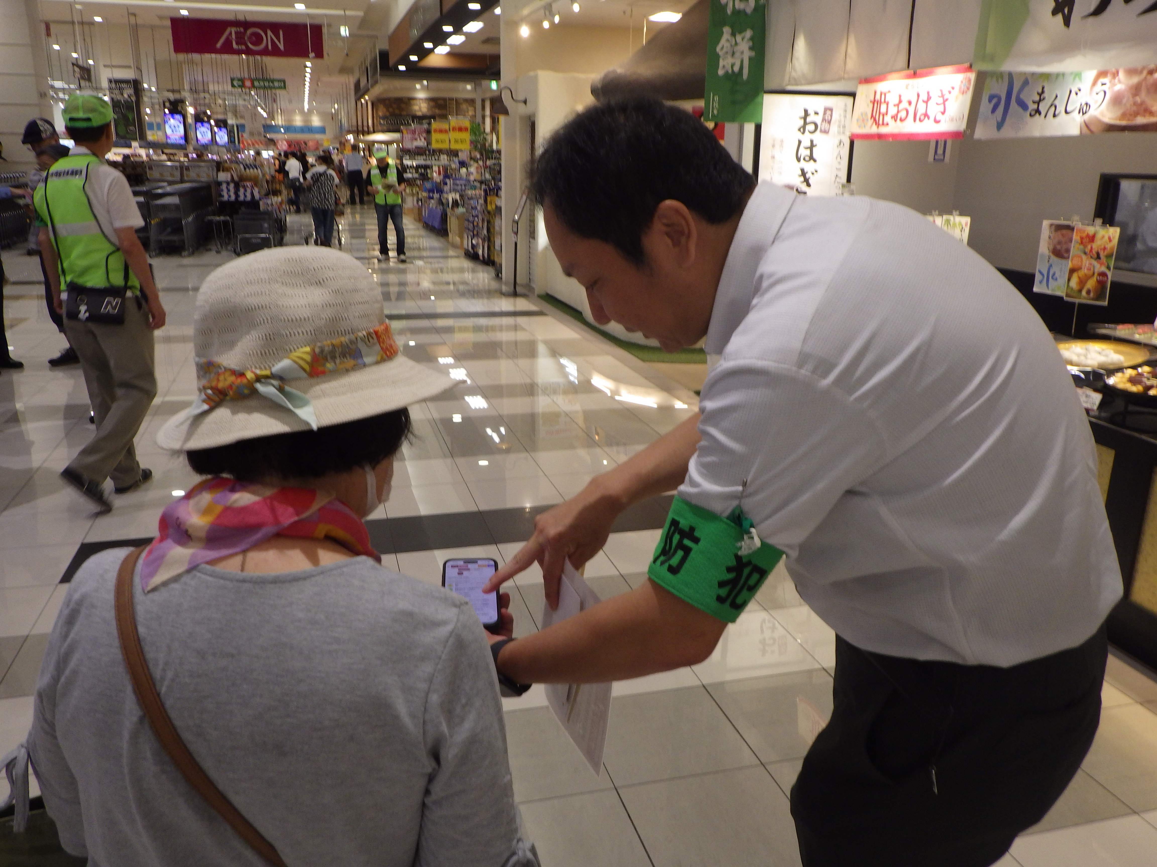 来客者にナポリスアプリの案内をしている様子