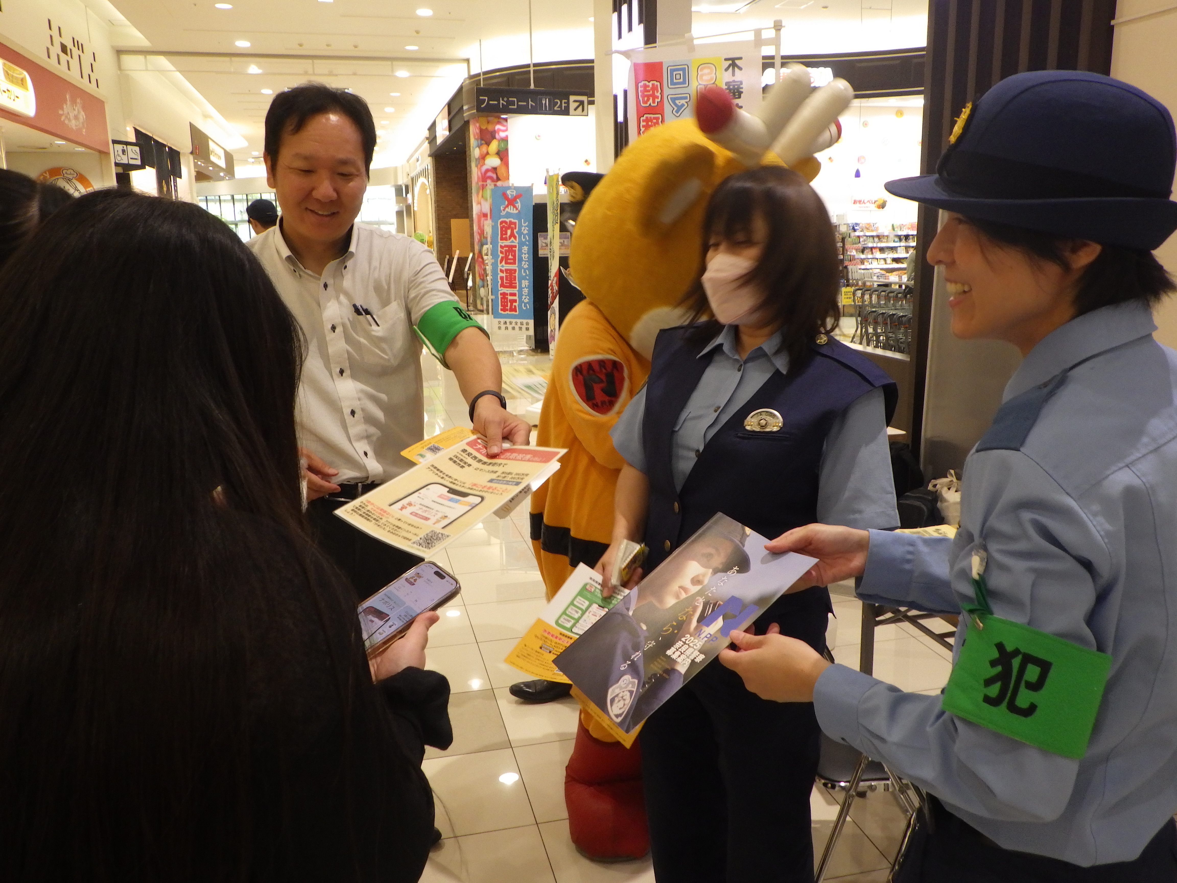 警察官が来客者に警察やナポリスの案内をしている様子
