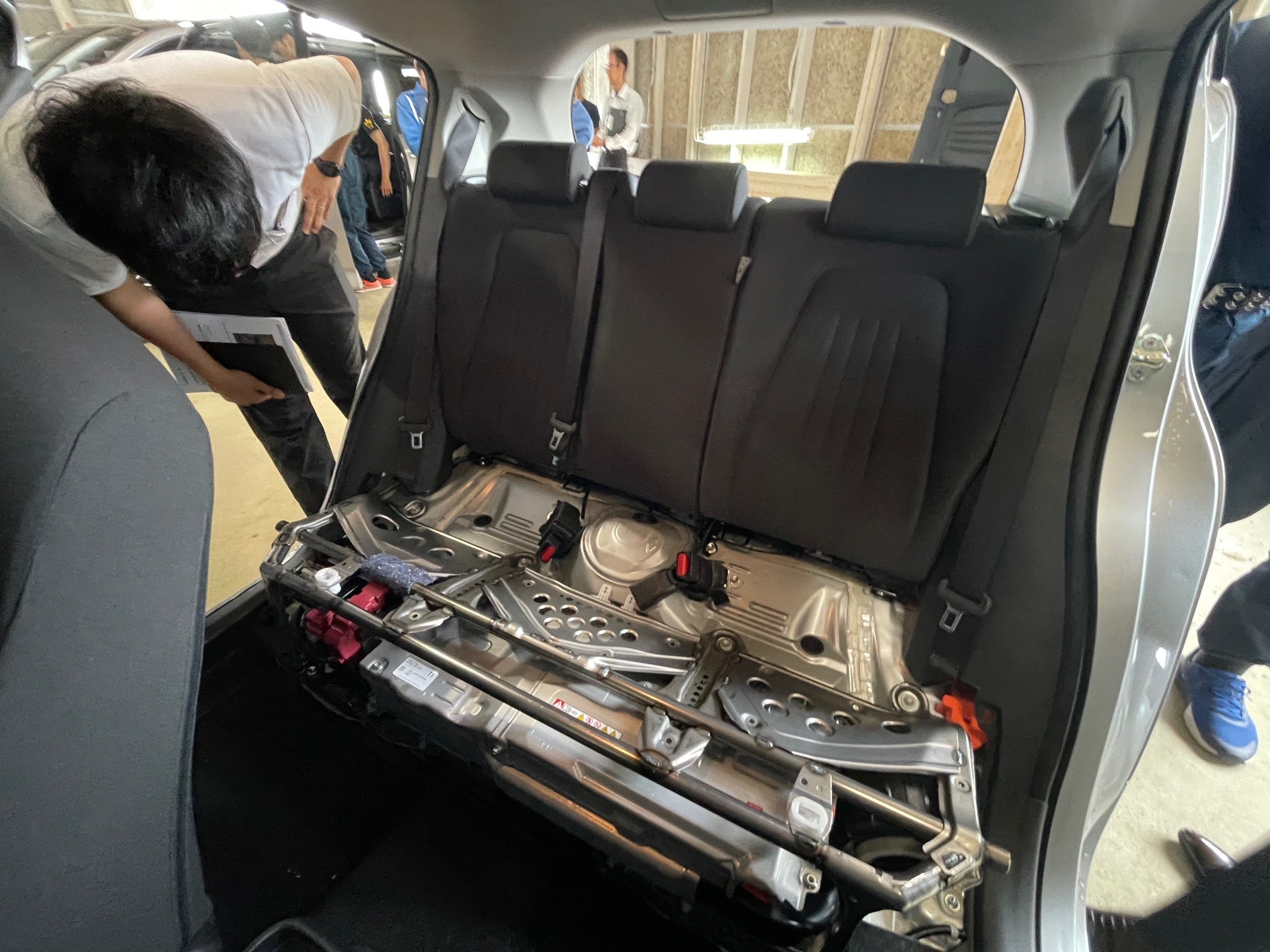ハイブリットカー車内の中の設備について教養を受ける様子