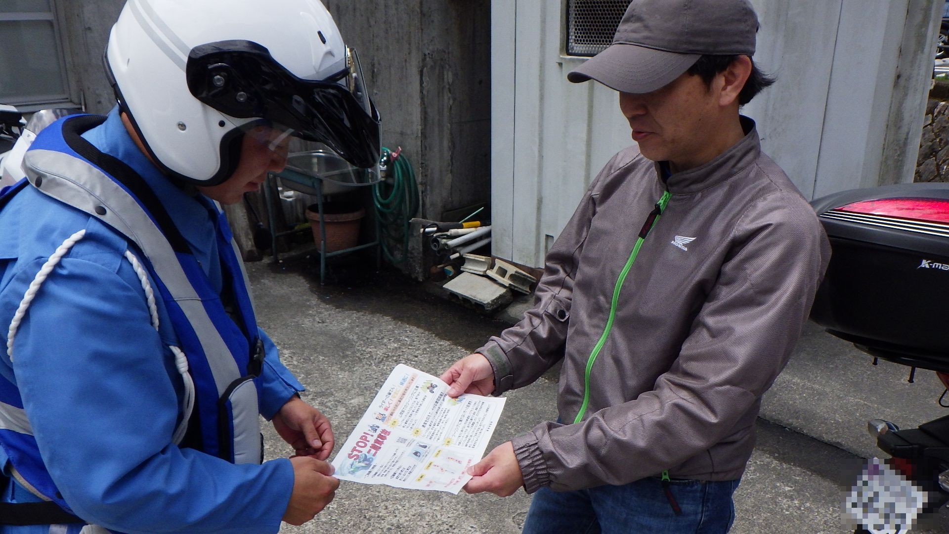 白バイ隊員がライダーに二輪車事故について注意喚起する様子