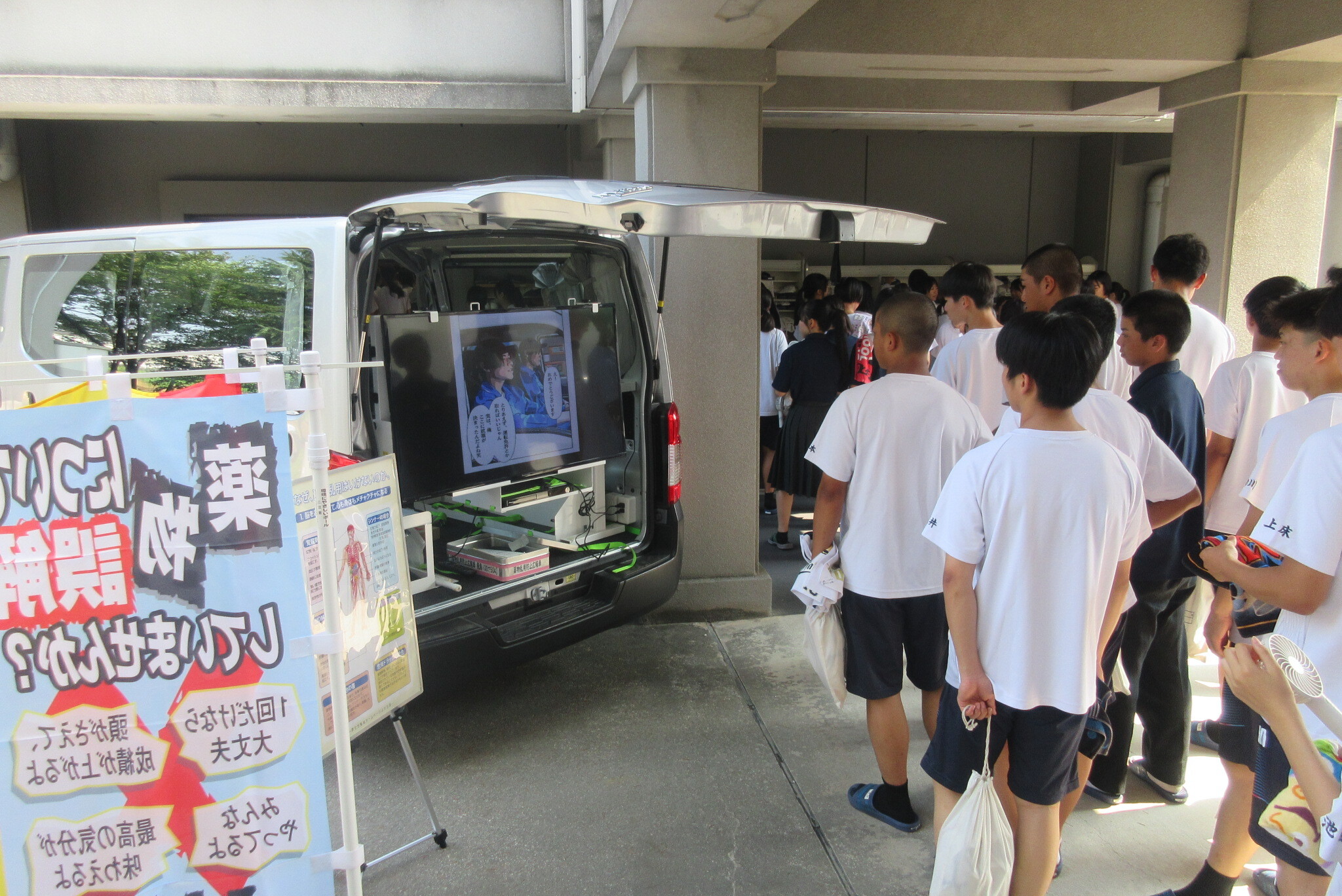 薬物乱用防止広報車を生徒が見る様子