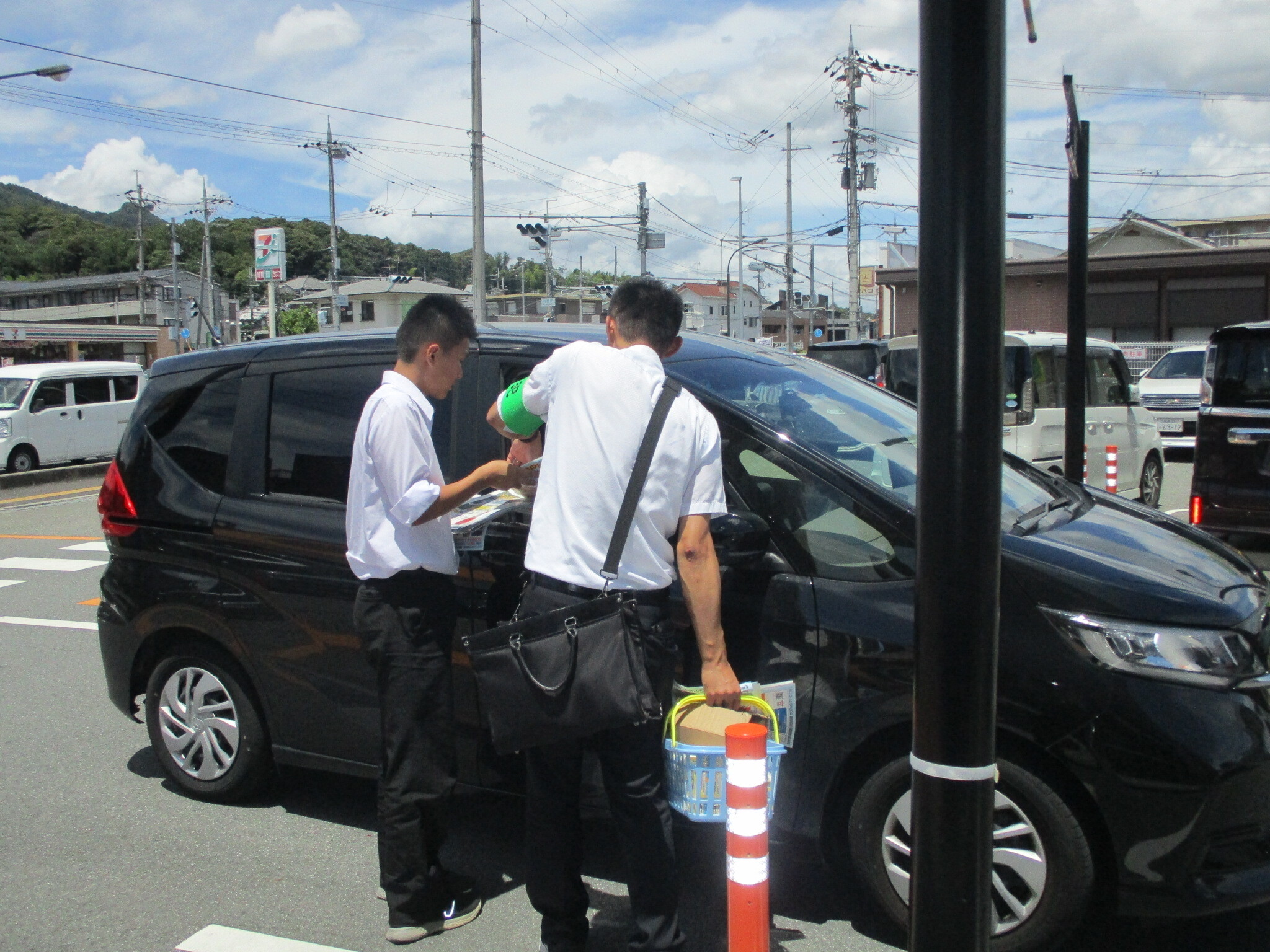 店外でお客さんへ特殊詐欺被害防止のチラシの案内をしている様子2