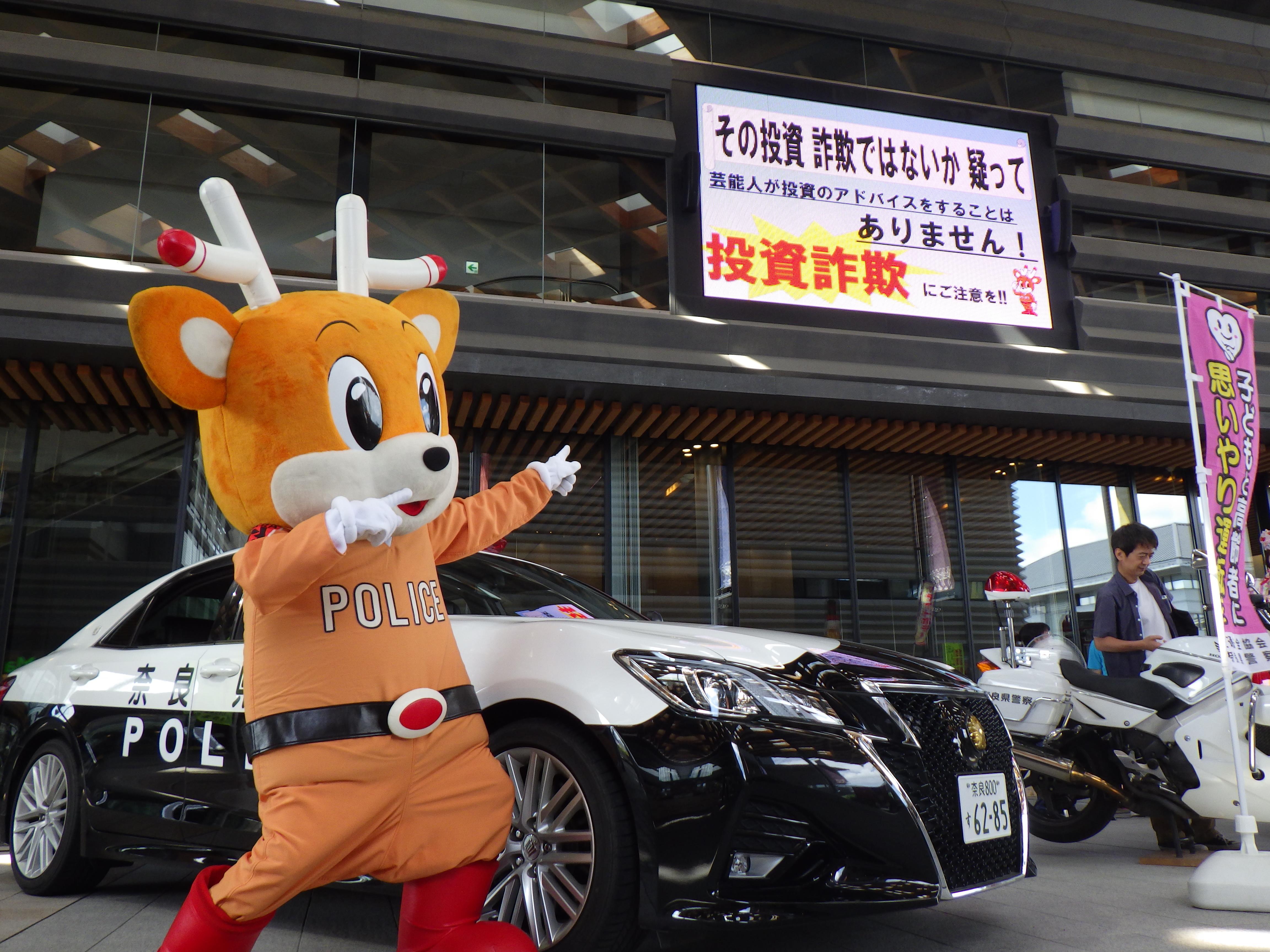 ナポくんが詐欺防止掲示板を指さす様子