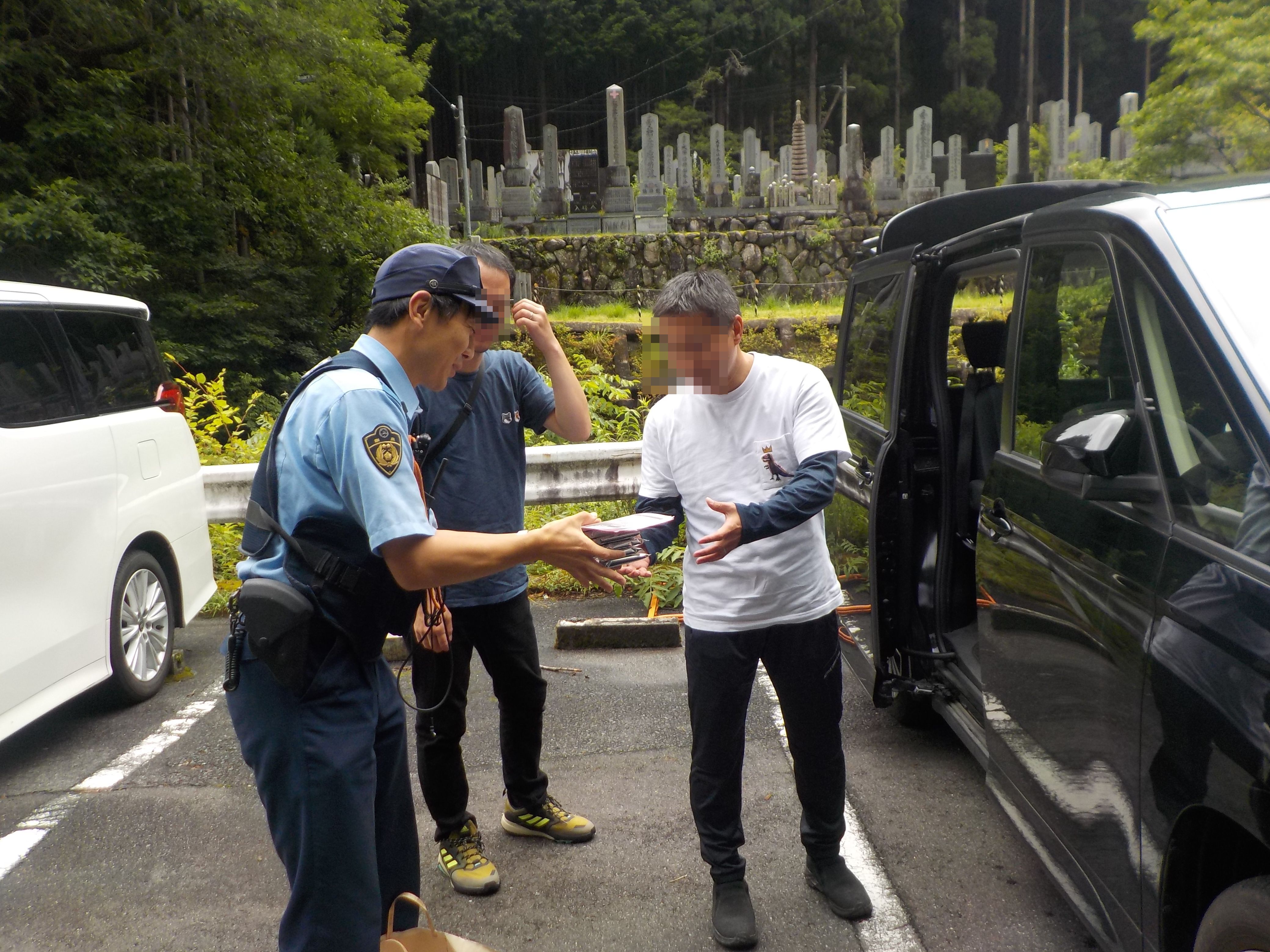 登山者に警察官が啓発チラシ等を配布している様子