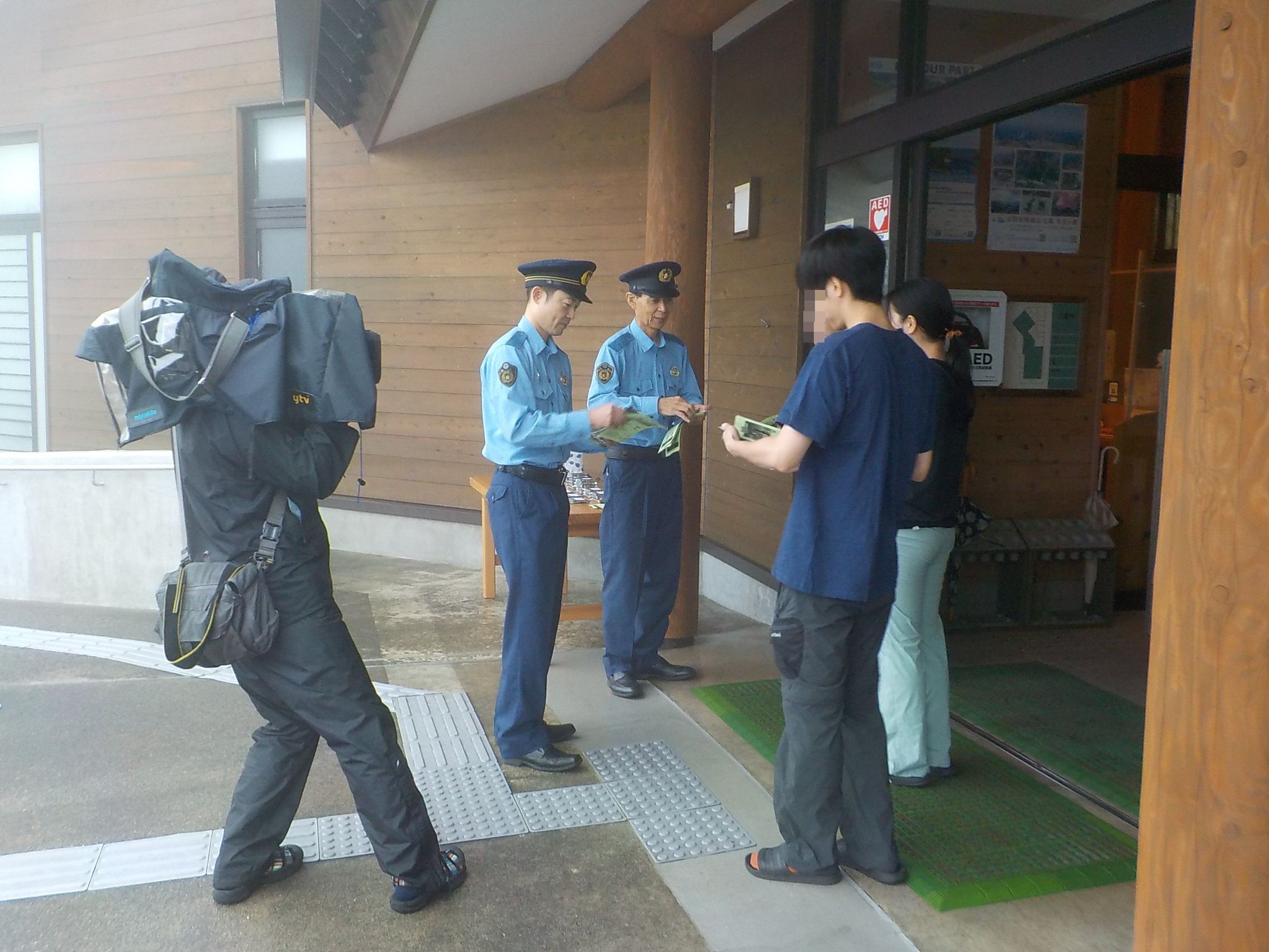 登山客へ警察官が登山届等の山岳遭難防止啓発チラシを配布している様子