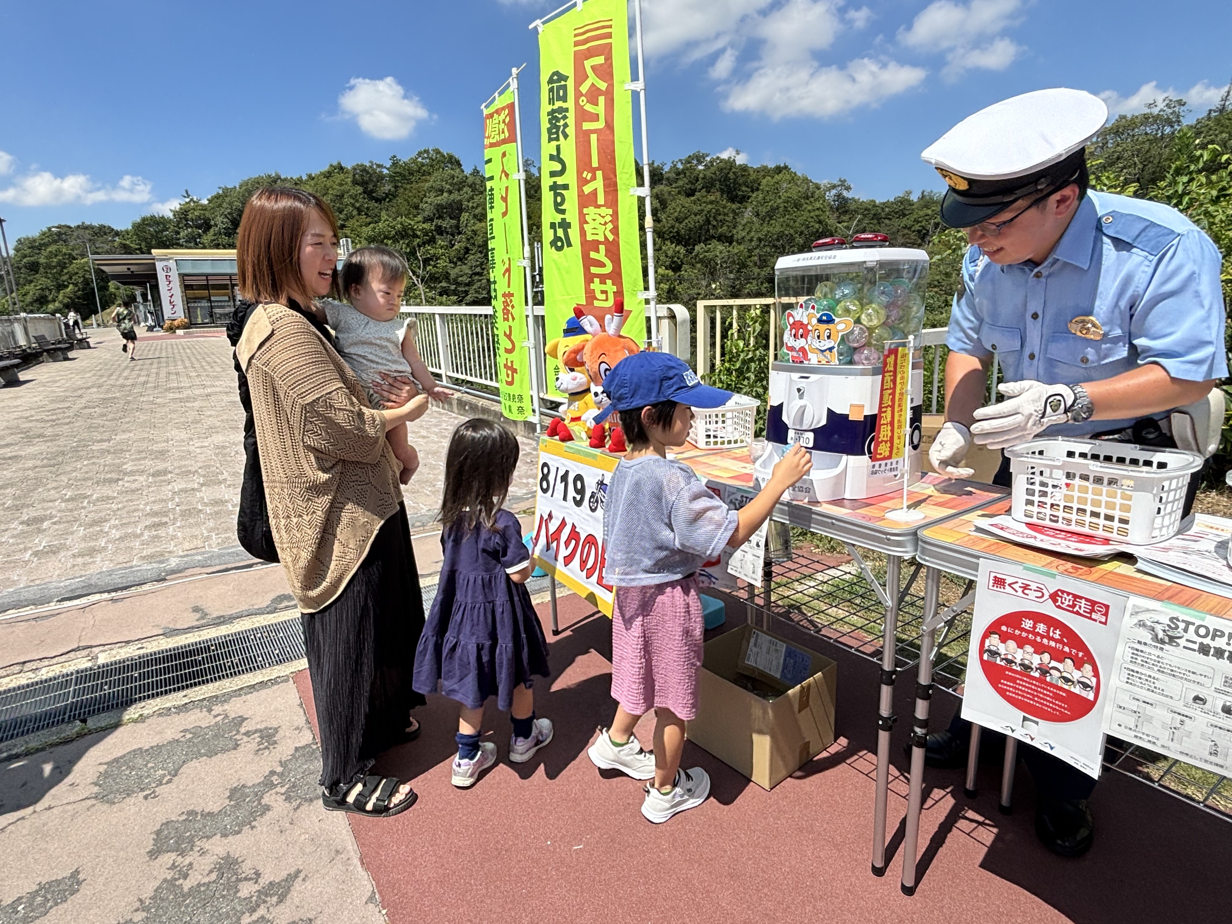 子どもがカプセルトイを回し、啓発物品をプレゼントする様子