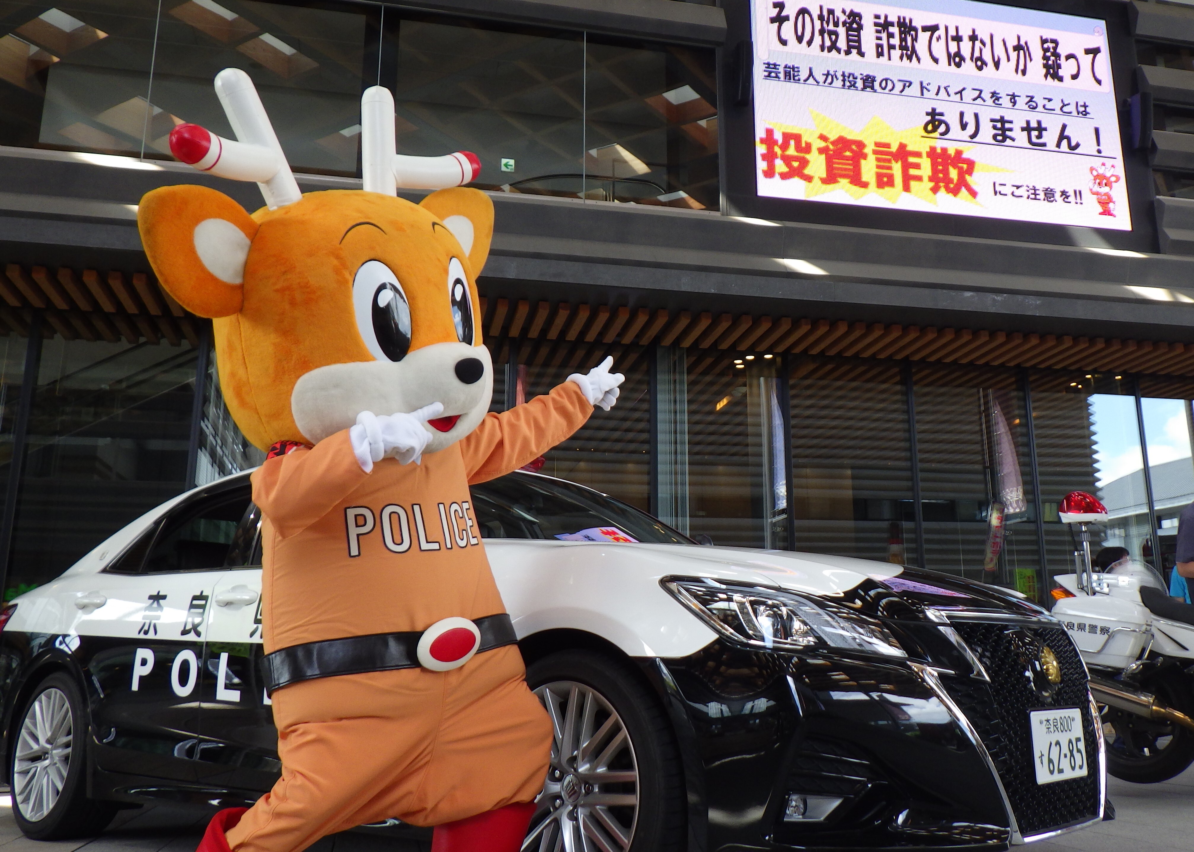 ナポくんが詐欺防止掲示板を指さす様子