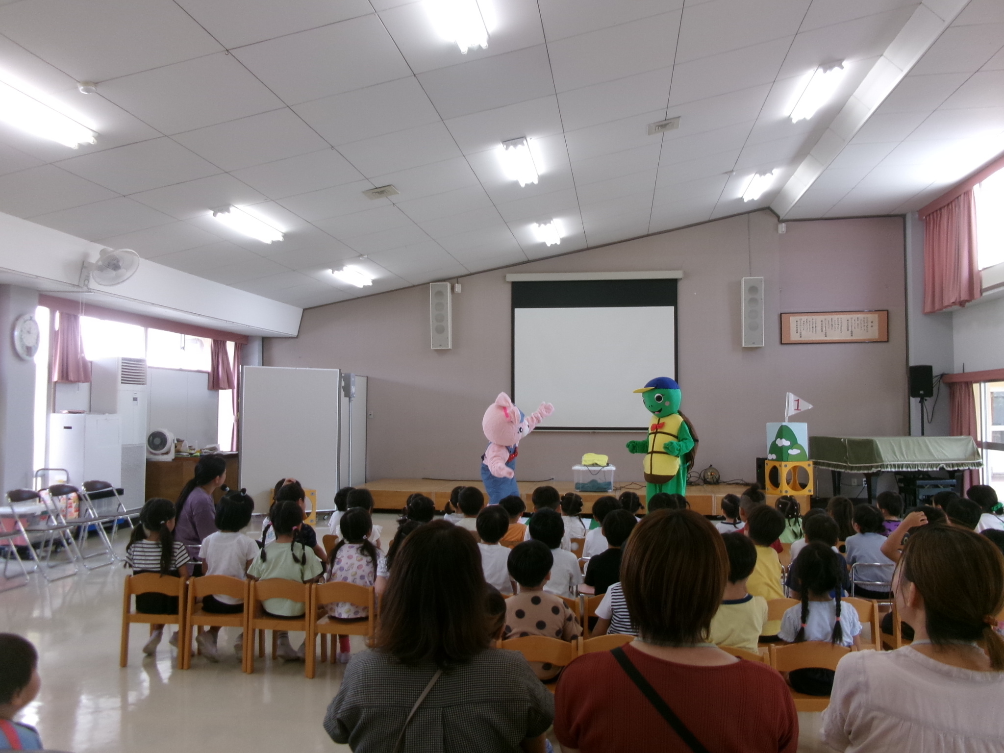 園児たちがきぐるみの劇を見ている様子