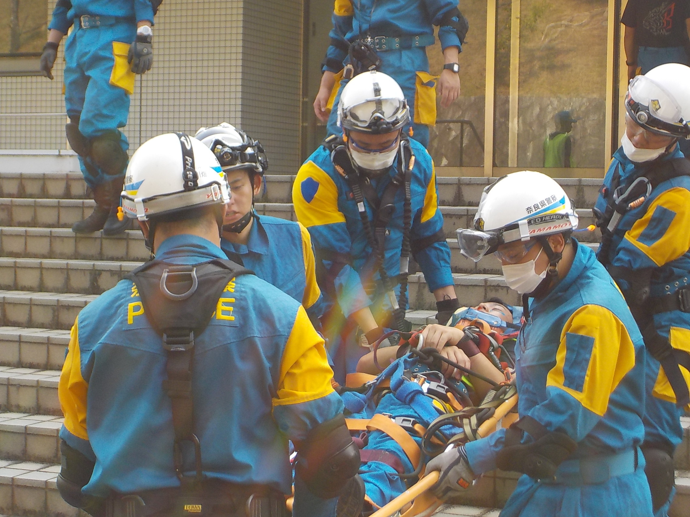 訓練で機動隊員が担架でけが人を外に運び出している様子2