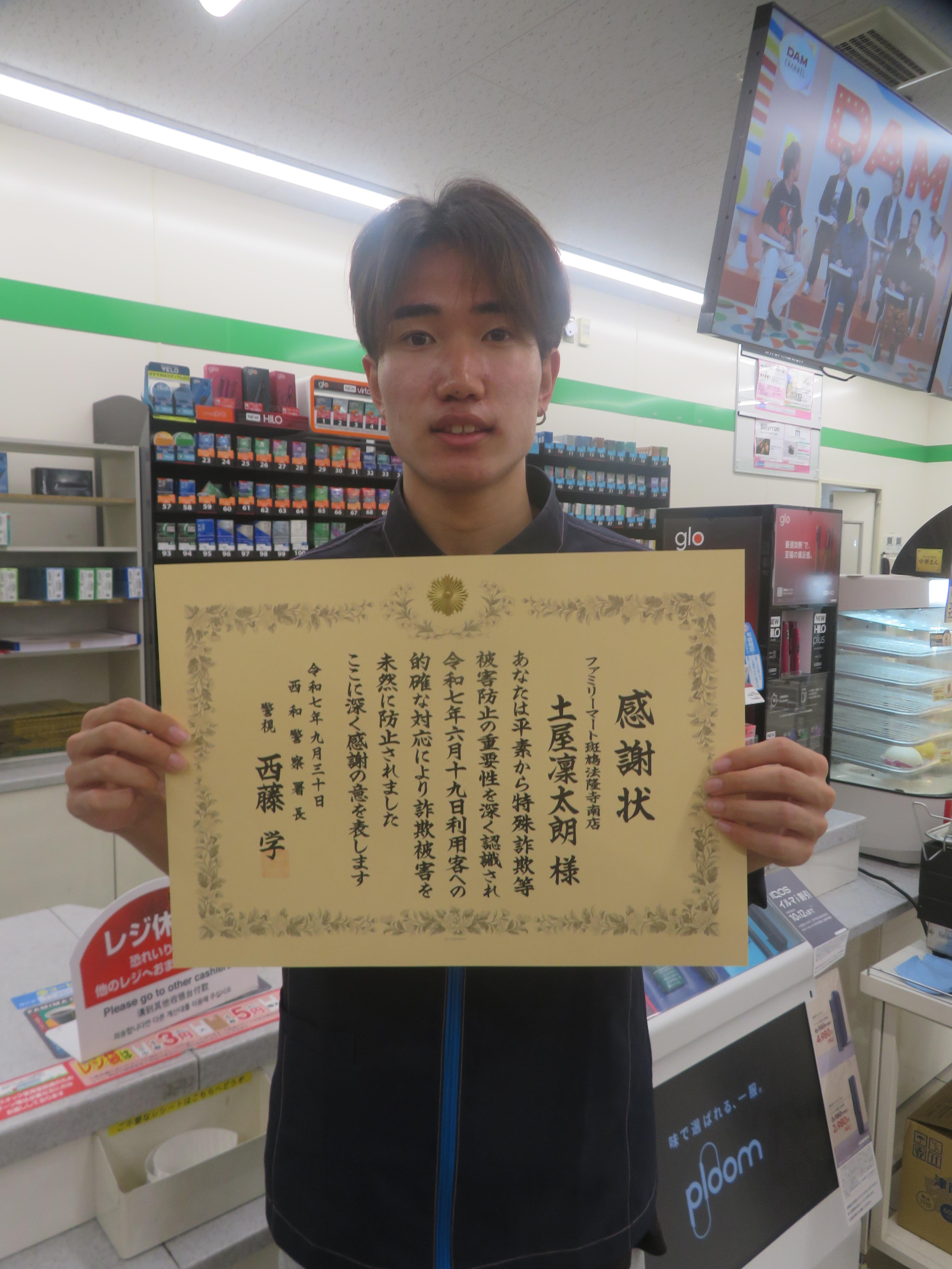 感謝状をもち写真撮影する様子2