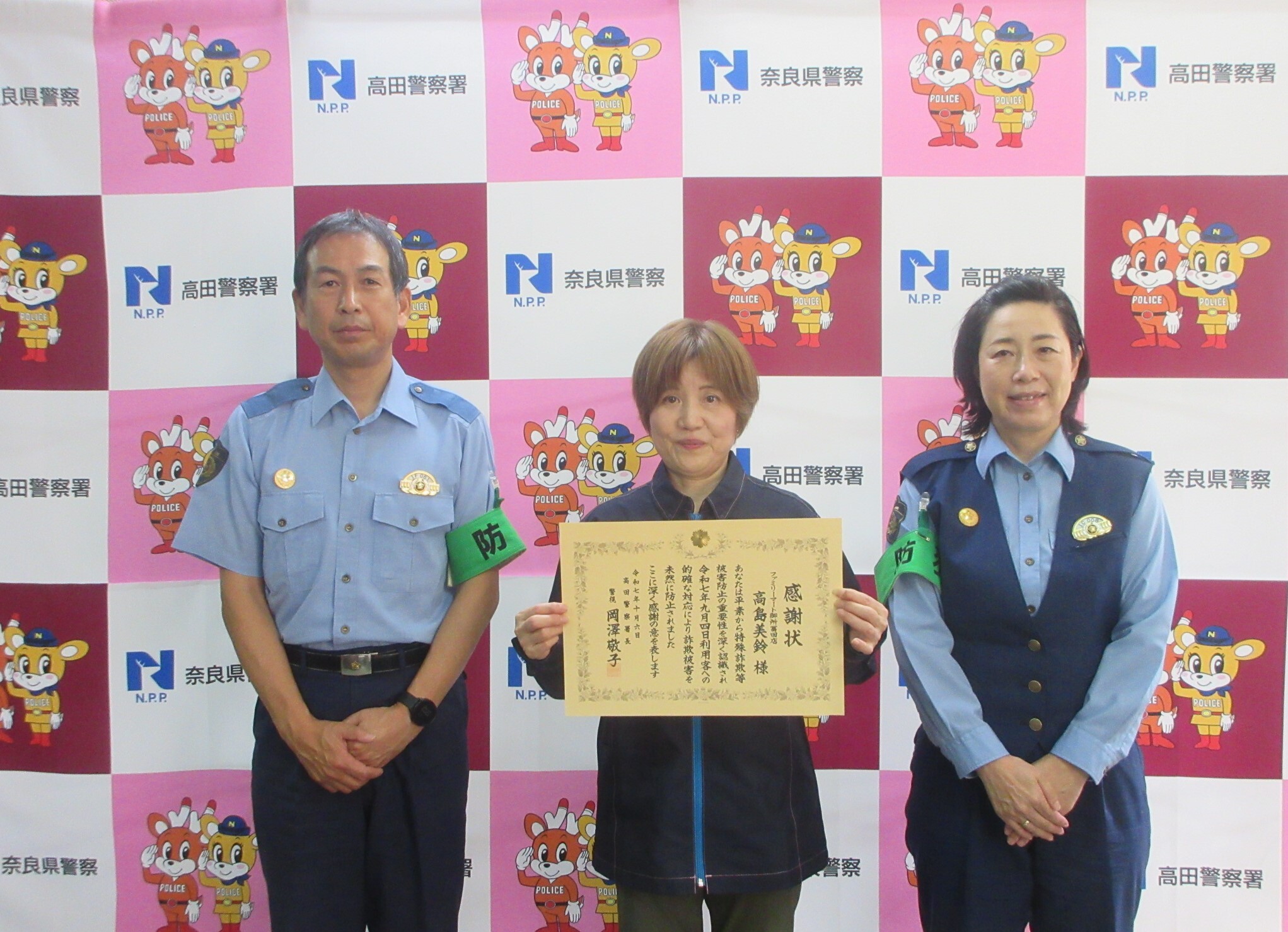 署長らと並んで写真撮影する様子