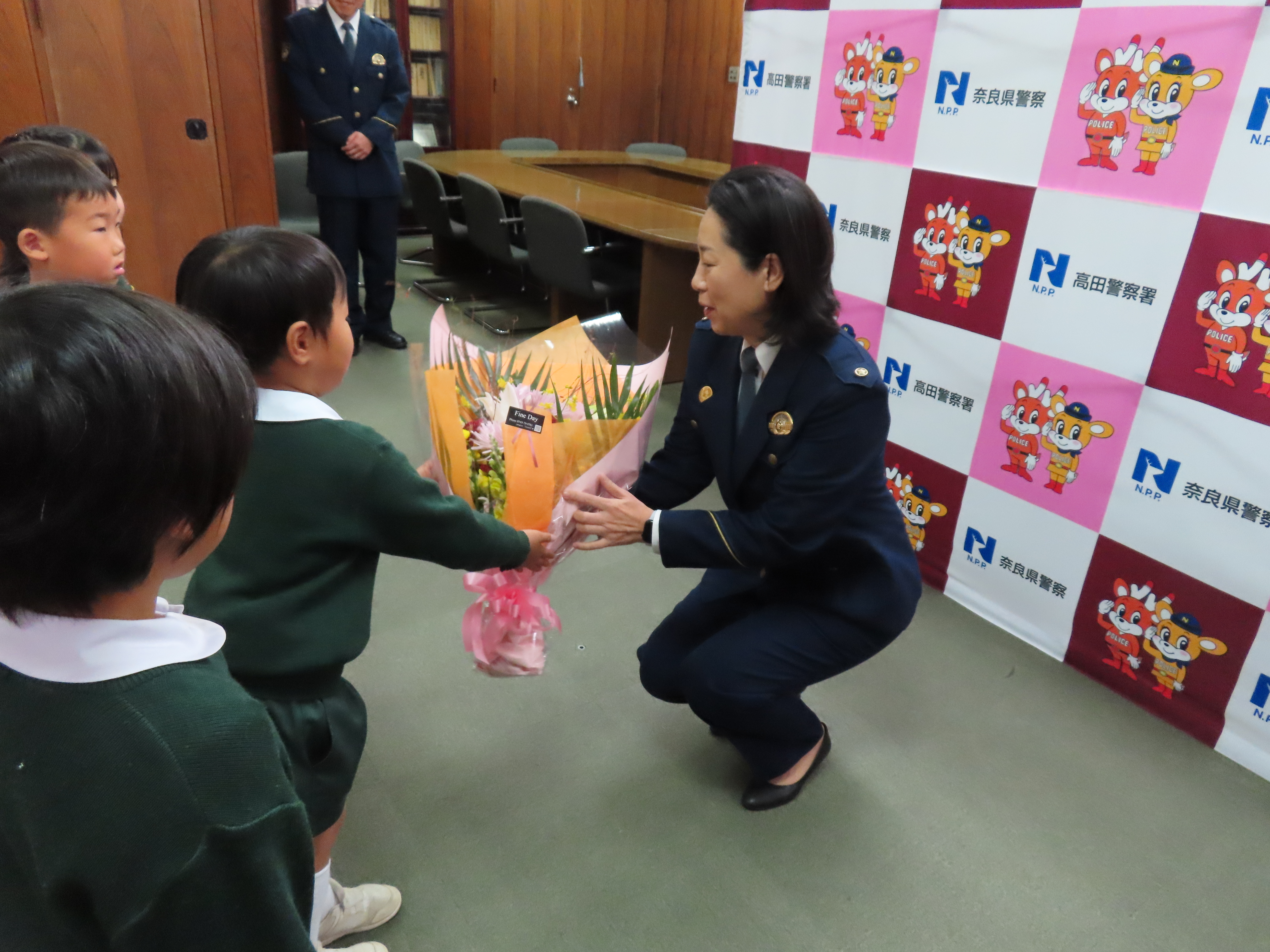 園児が高田署長へ花束を手渡している様子