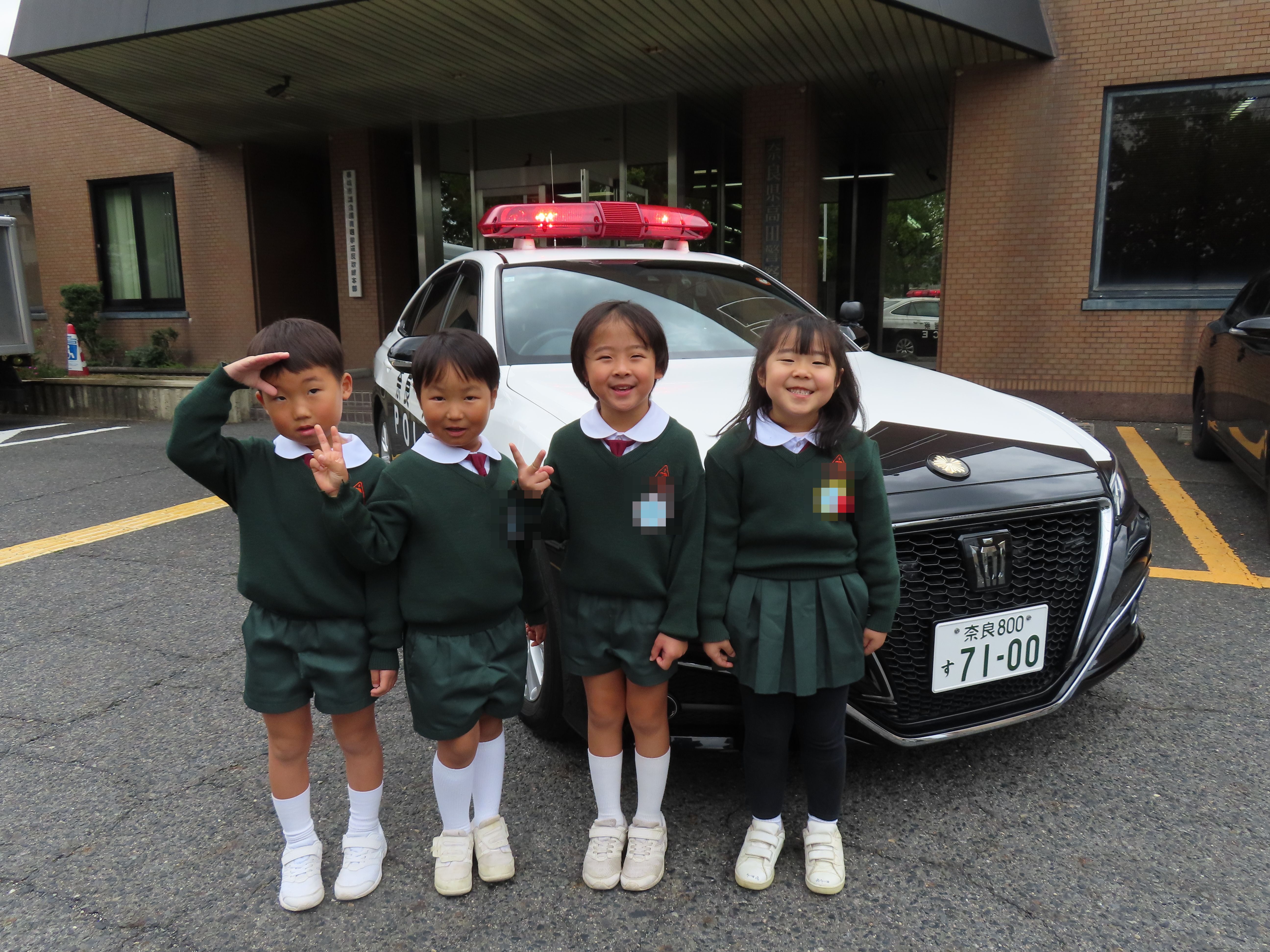 園児達がパトカーの前で並んでいる様子