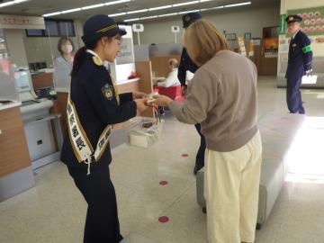 チラシを客に配る女性