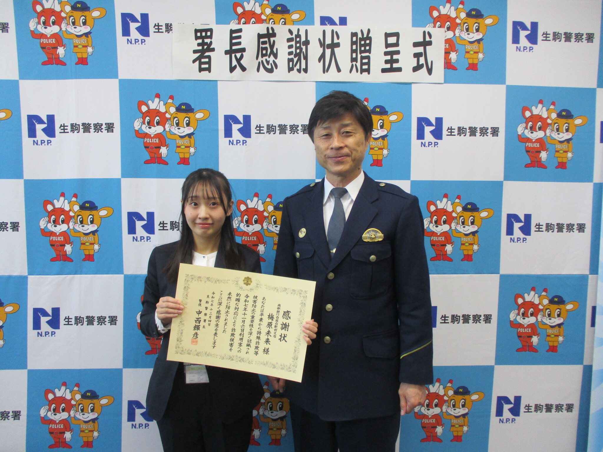 感謝状を手に持ち署長と並ぶ様子