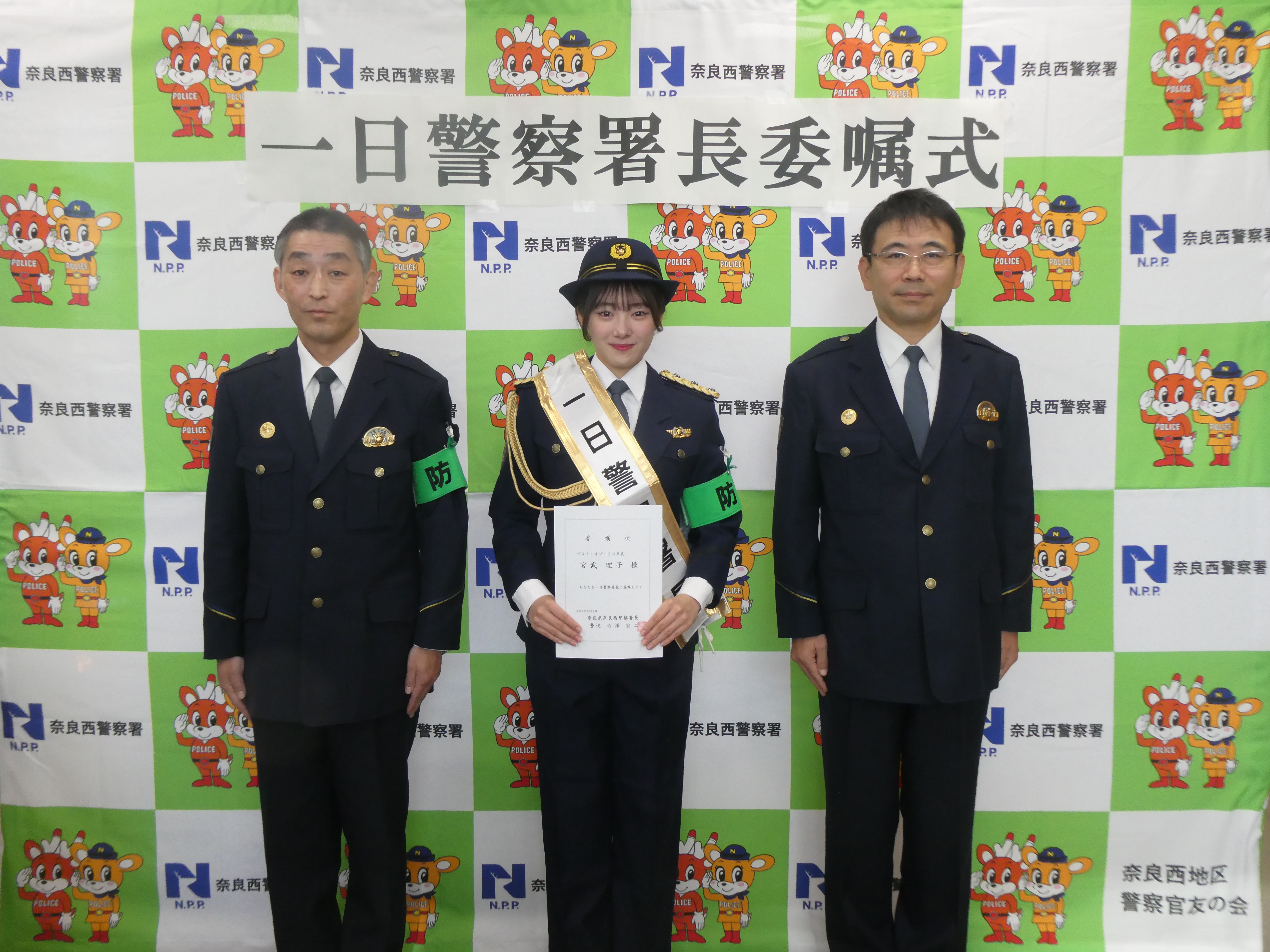 一日警察署長と署長らが並んで写真撮影する様子
