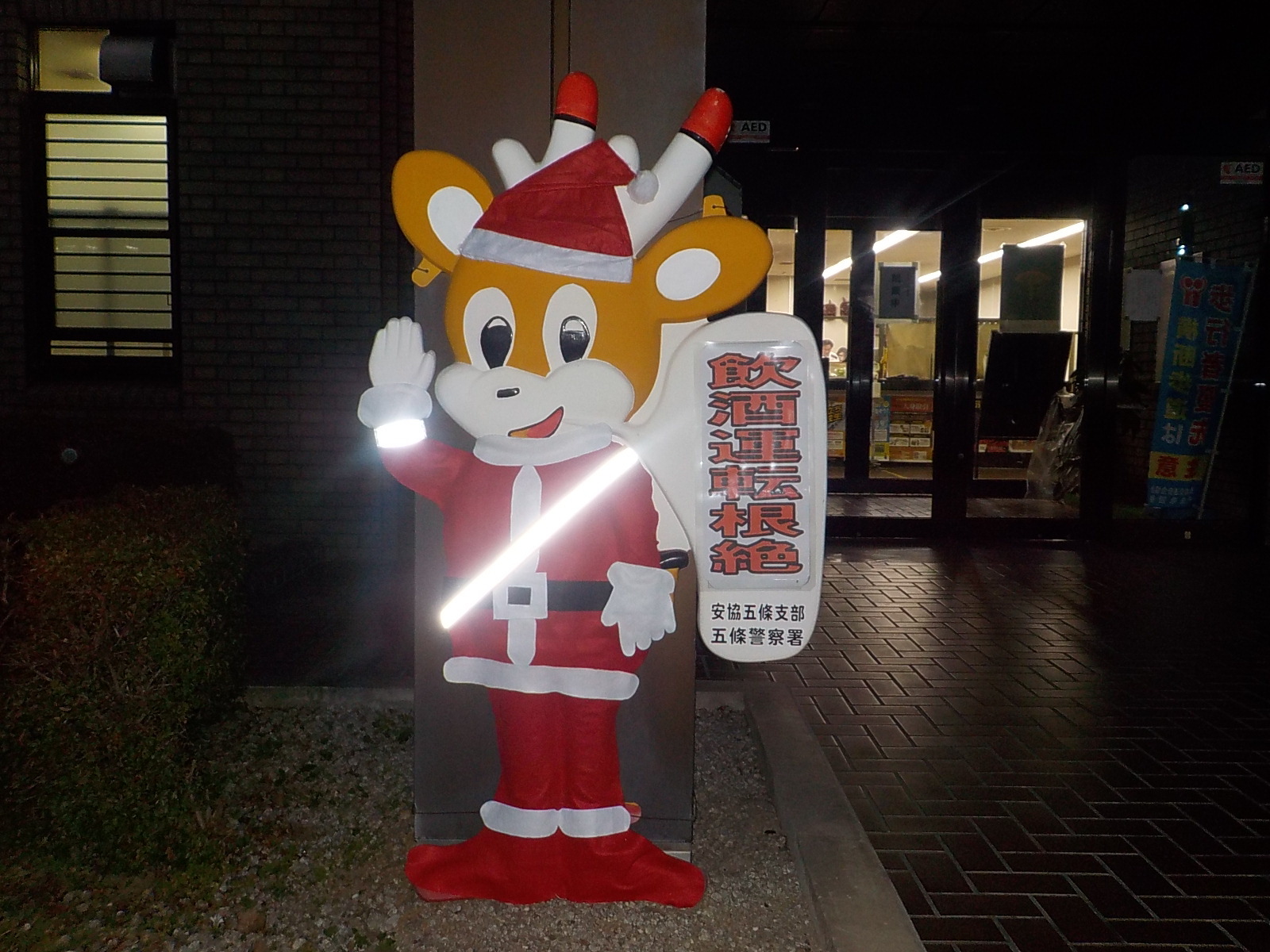 五條署の前でサンタ服を着ているナポくん