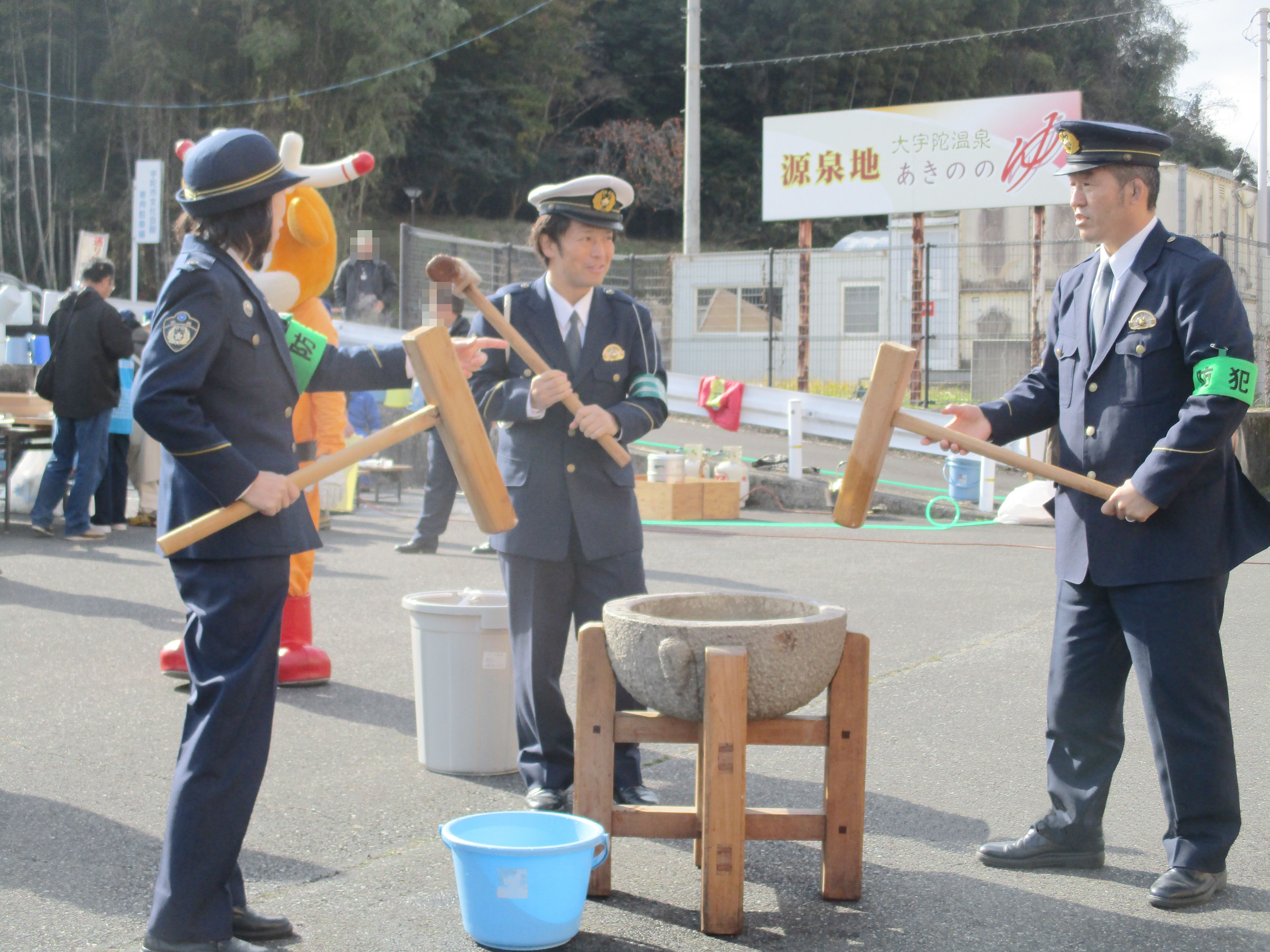 警察官が杵を持って餅つきをしている様子