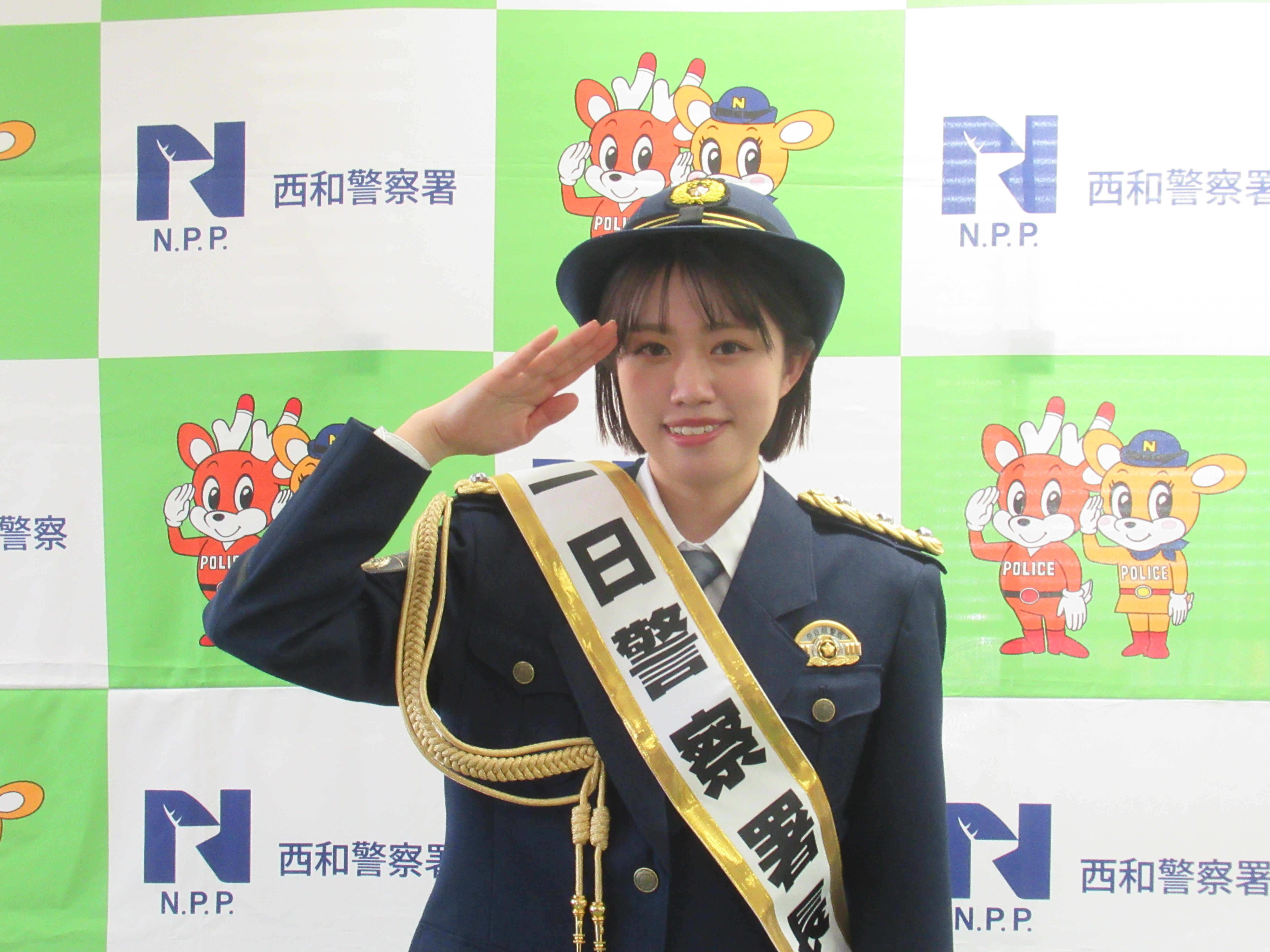 一日署長が敬礼をしている写真