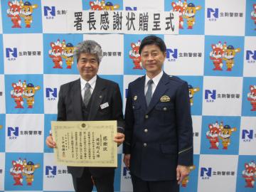 感謝状を手に持ち署長と並ぶ様子