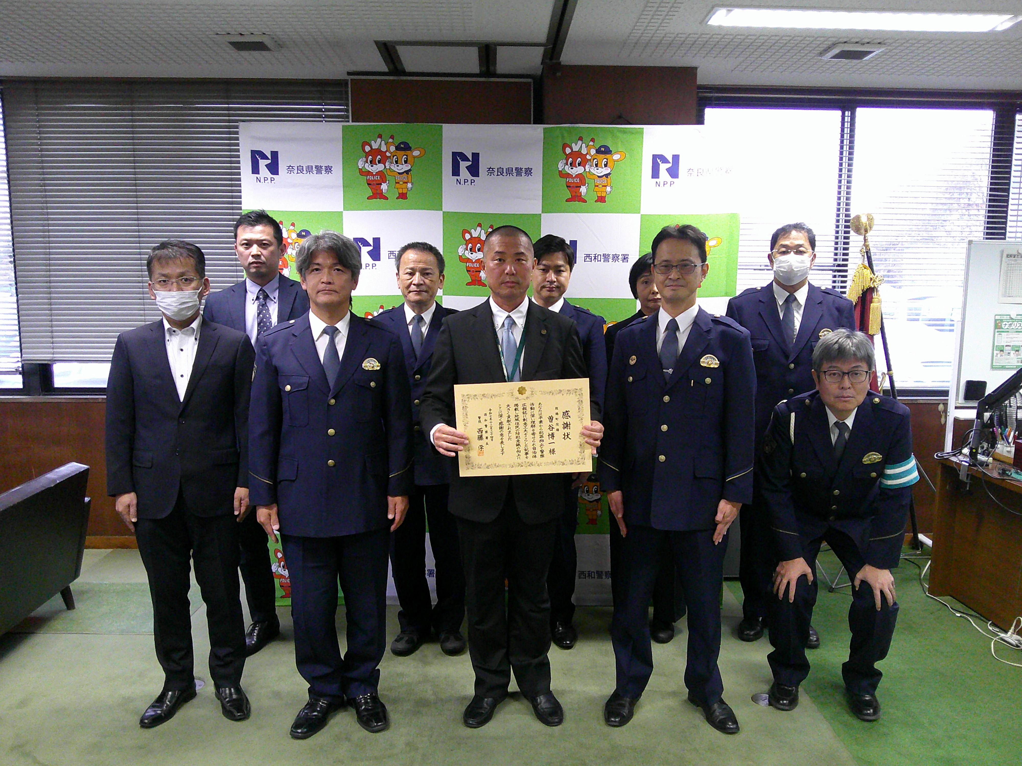 感謝状を持って写真撮影の様子