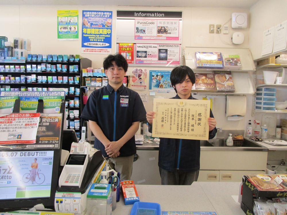 店のレジ前で感謝状を持って並んでいるようす